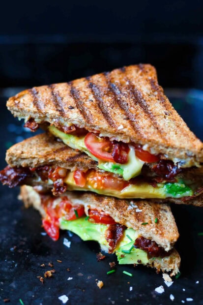 A delicious sandwich with bacon tomato and avocado on grilled bread in close up