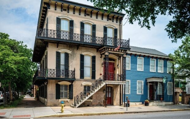 Historic Savannah Georgia building with iron balconies and lush greenery
