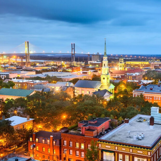 Historic Savannah Georgia cityscape with church steeple and bridge at dusk