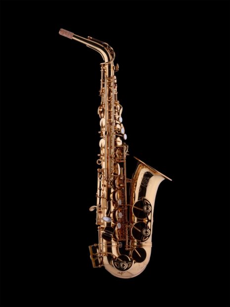 A detailed saxophone with shining golden keys isolated on a black background
