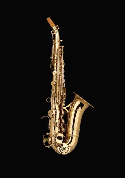 A golden saxophone with detailed keys on a black background