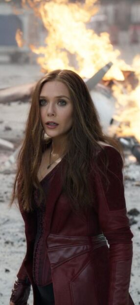 Scarlet Witch character standing with fire explosion in the background wearing a red outfit