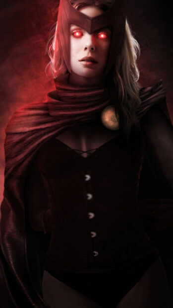 Scarlet Witch with glowing eyes wearing a red costume and cape in a dark setting