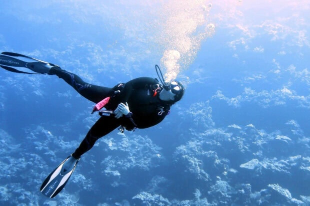 A scuba diver exploring underwater with bubbles rising from equipment