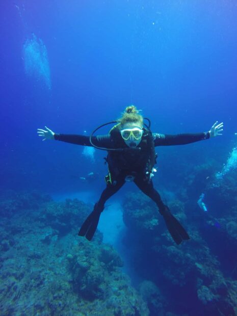 A scuba diver exploring vibrant coral reefs underwater