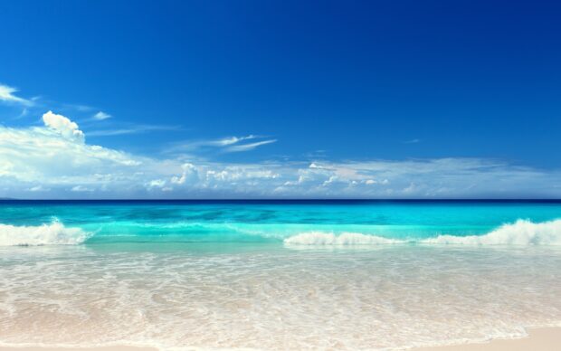 Clear seascape with turquoise waters and gentle waves under a bright blue sky