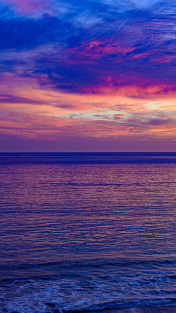 Calm seascape with a colorful sky during sunset reflecting on the ocean surface