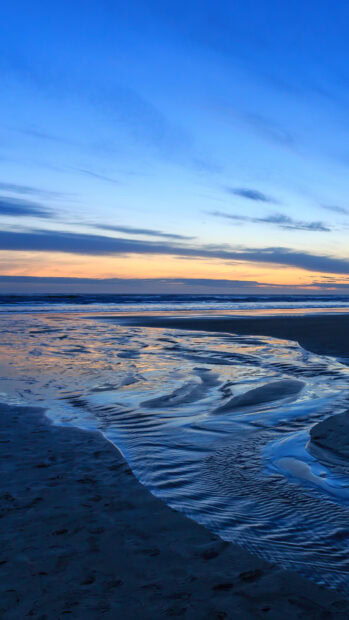 A peaceful seascape with calm water and beautiful sunset sky at the beach in 4K resolution