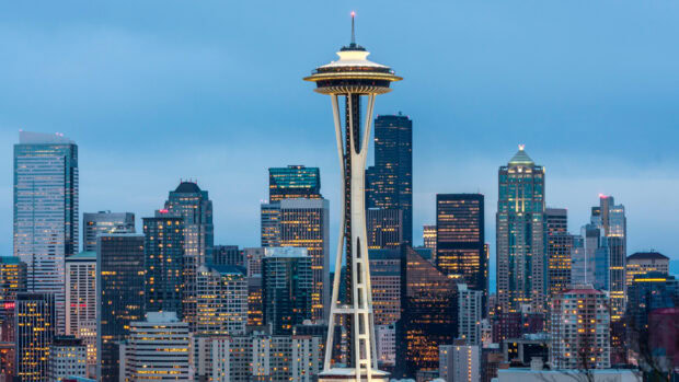 The Seattle skyline features the iconic Space Needle standing tall among city buildings at dusk