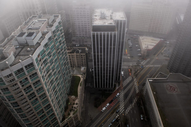 Aerial view of Seattle cityscape with tall buildings and foggy weather conditions