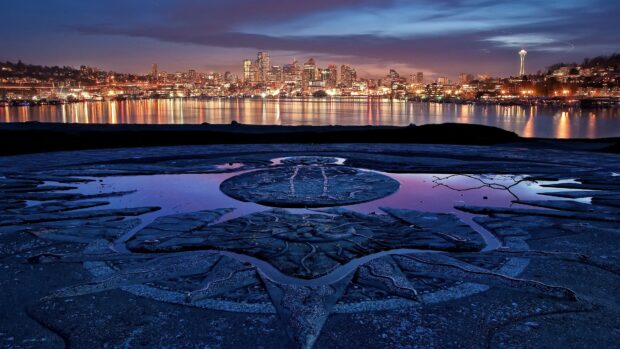 Seattle artistic stone carving reflecting city skyline at dusk