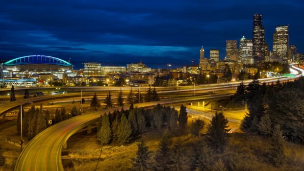 Night view of Seattle cityscape with highway and illuminated skyscrapers