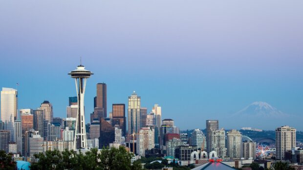 Seattle city skyline with the space needle and mountain in the background at dusk
