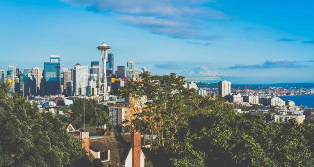 A stunning Seattle cityscape with skyline and lush greenery under a clear blue sky