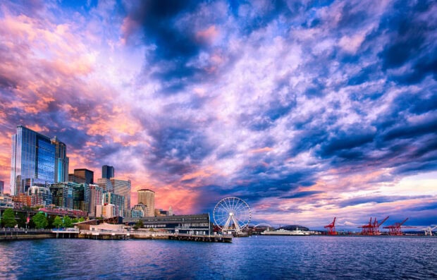 Seattle city skyline at sunset with vibrant clouds over the waterfront