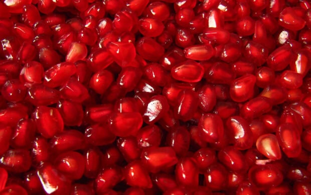 Close up of red pomegranate seeds filling the entire frame