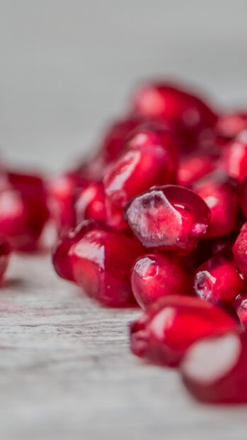 Close up of fresh seeds with glossy red surface on a wooden table