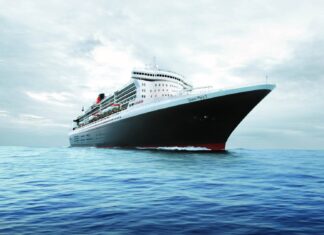 White cruise ship sailing on calm blue sea with cloudy sky in background