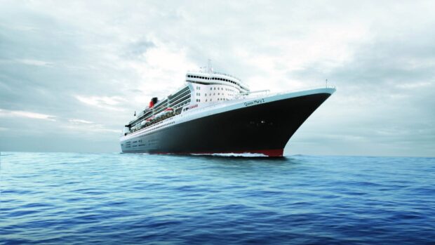 White cruise ship sailing on calm blue sea with cloudy sky in background