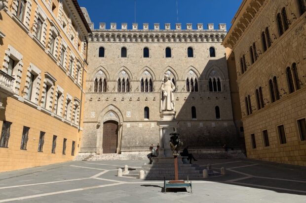 Historic Siena architecture with statue in the courtyard of the old city center