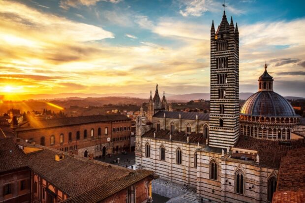 Historic Siena skyline with cathedral and sunset over ancient cityscape
