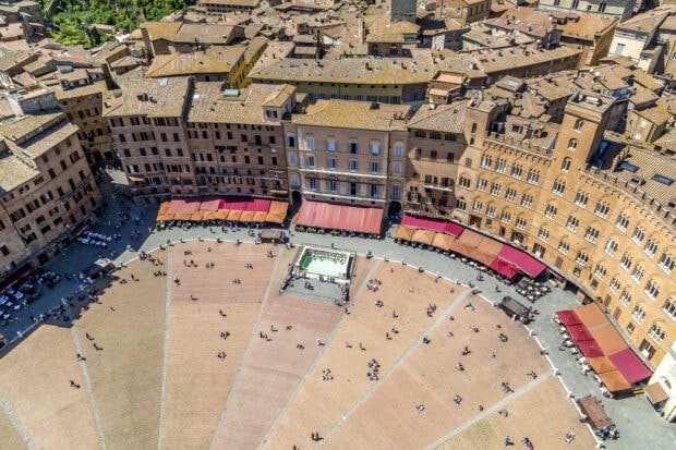 Aerial view of Siena old town square with historic buildings and outdoor seating areas