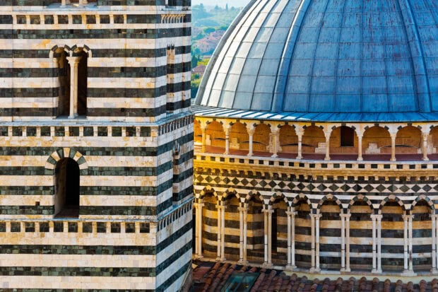 Historic Siena architecture showcasing striped stone tower and dome details