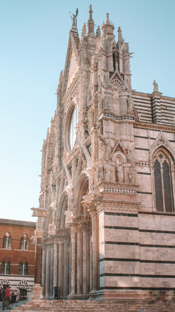 Gothic architecture of Siena cathedral with intricate sculptures and striped marble facade