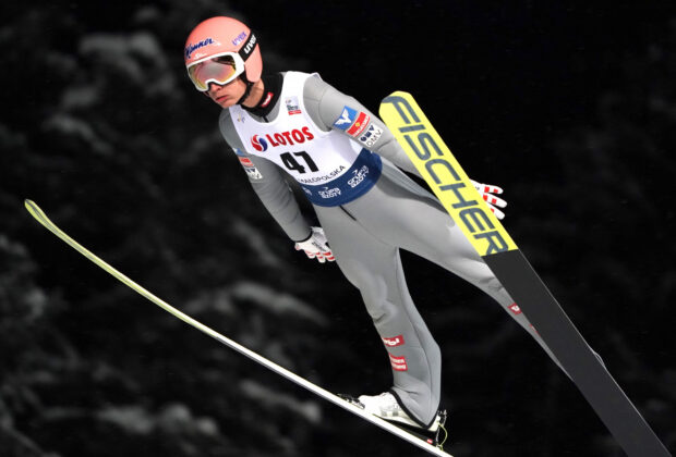 Ski jumping athlete in midair performing a jump during a ski competition