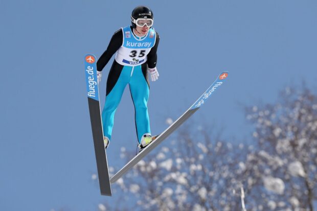 Ski jumping athlete in mid air performing a jump during competition