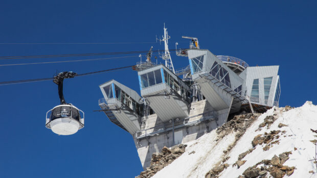 A ski lift station on a snowy mountain under a clear blue sky