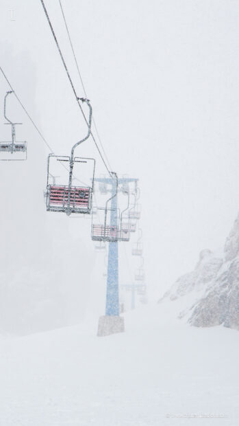 Ski lift covered in snow on a snowy mountain slope