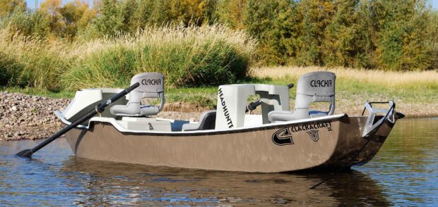 A skiff boat with two seats floating on a calm river near grassy riverbank