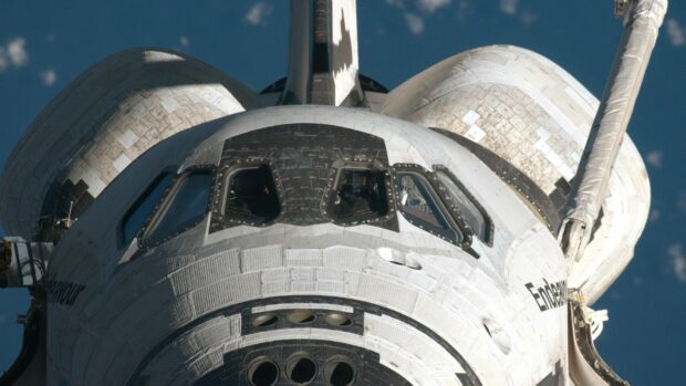 A close up view of space shuttle cockpit showing detailed thermal tiles and windows in space