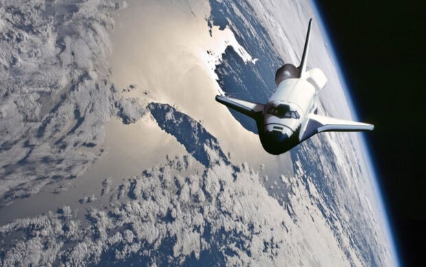 A space shuttle orbiting Earth in outer space showing detailed clouds and oceans