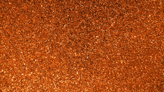 A close up view of orange sparkle glitter texture