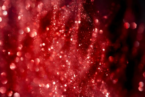 Red sparkle texture with glitter particles creating a vibrant sparkling effect