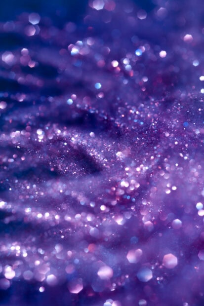 Close up of sparkle glitter in purple hues with bokeh effect