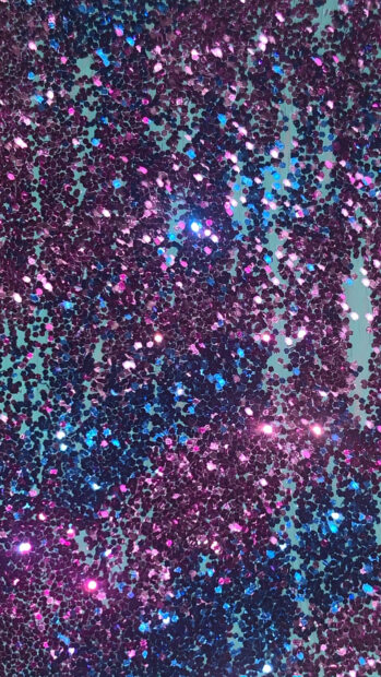 Glitter sparkle texture with vibrant purple and blue hues creating shiny effects