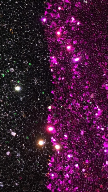 Sparkle texture with dark and vivid magenta colors reflecting light in high definition
