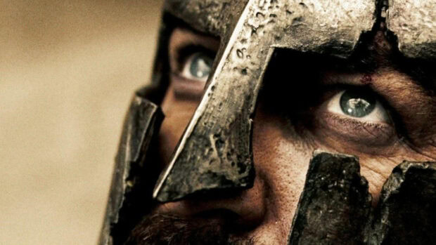 Close up of a Sparta warrior wearing a detailed helmet with intense eyes visible