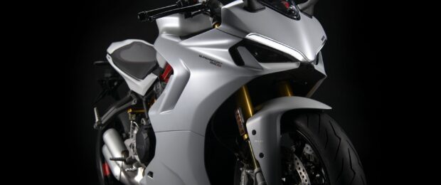 A close up view of a supersport 950S sports bike in silver color on a black background