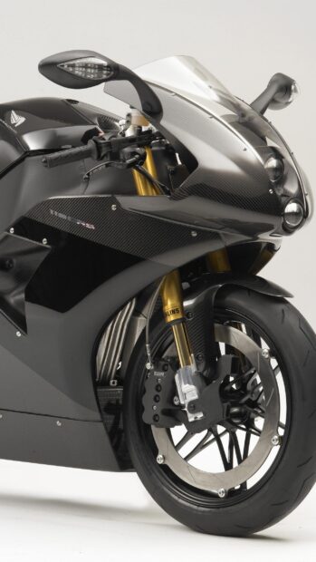 Close up of sports bike front wheel and carbon fiber body with golden suspension
