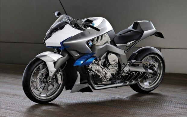 A sleek sports bike with a white and blue design parked on a wooden floor