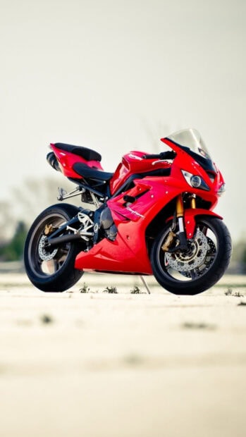 A red sports bike parked on a smooth surface showcasing a sleek design and powerful features