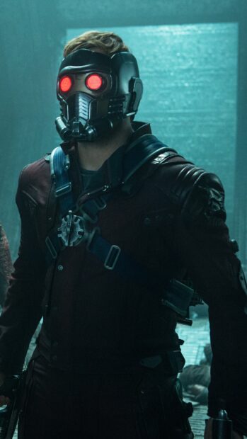 Star Lord wearing a futuristic mask with glowing red eyes in a dark environment