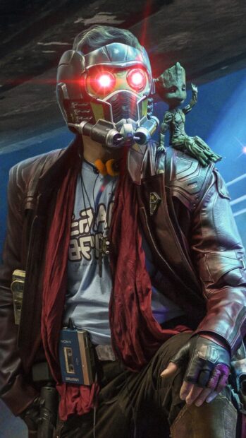 Star Lord wearing a helmet with glowing eyes and Groot sitting on his shoulder