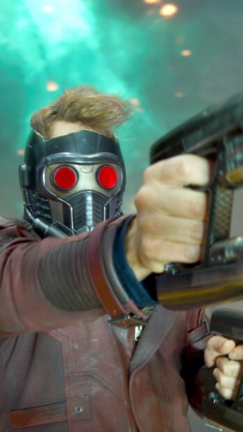Star Lord wearing a mask and aiming with a futuristic weapon