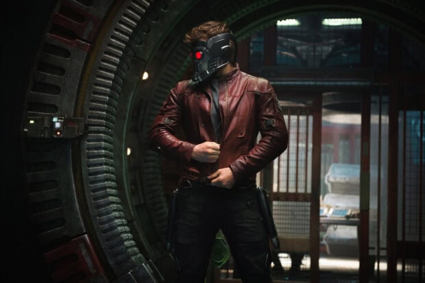 Star Lord standing in a futuristic setting wearing his signature helmet and red leather jacket