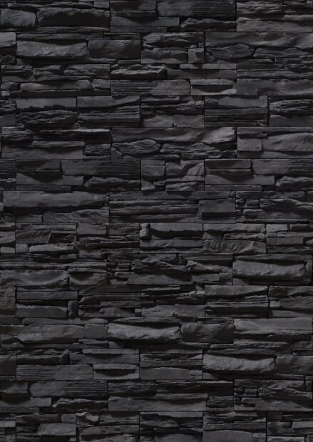 Dark textured stone wall displaying a variety of rough black stone pieces in a pattern